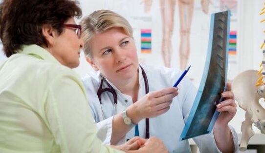 een arts onderzoekt een röntgenfoto voor rugpijn