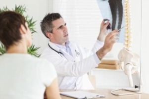 De arts voert een diagnose van degeneratieve discopathie op een foto